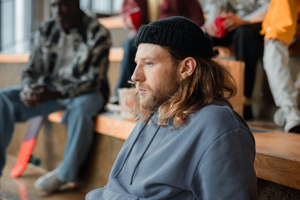 Portrait of a man with long hair and a beanie in a casual setting, capturing a thoughtful expression.